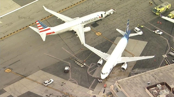 Wings of American, Alaska Airlines jets bump at airport